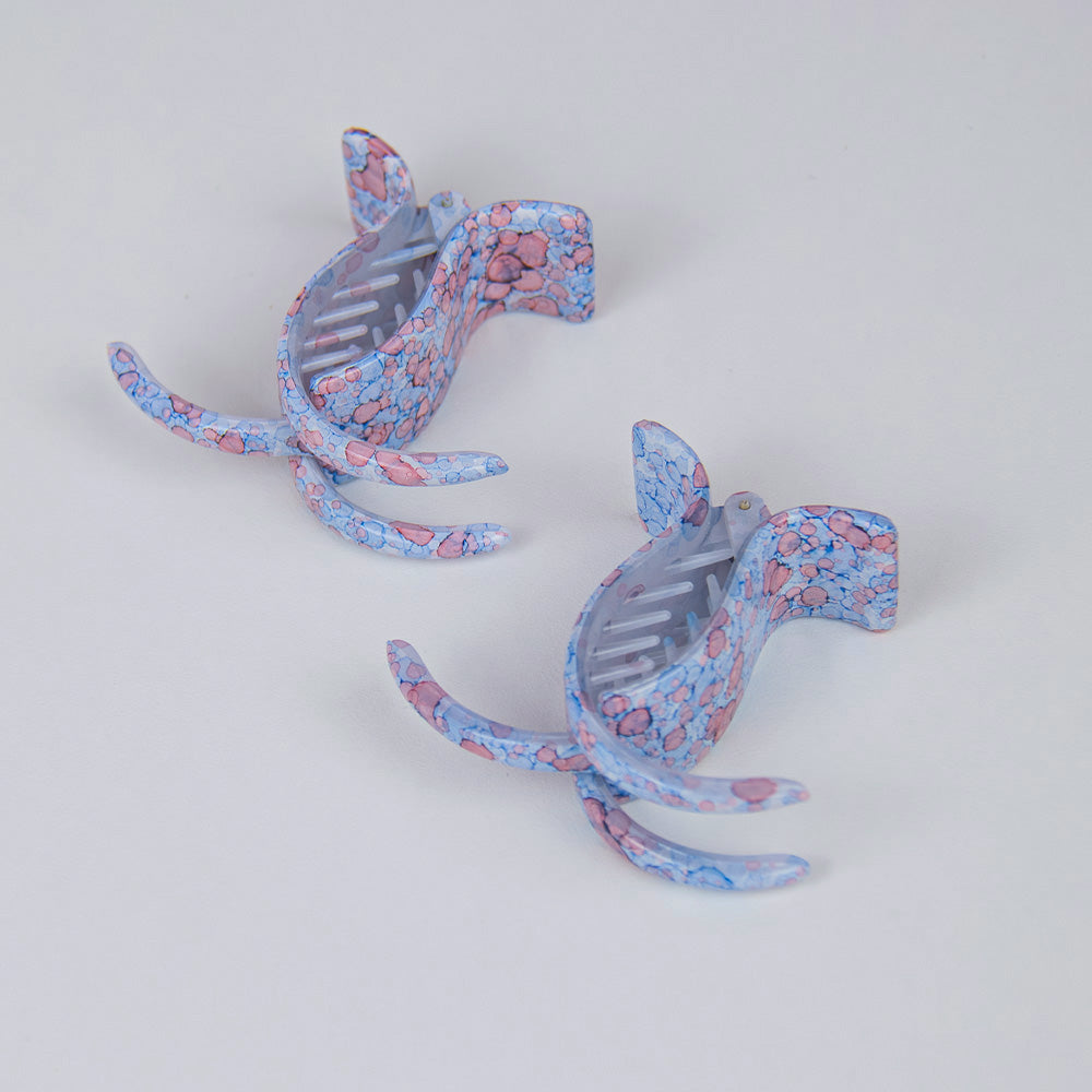 A pair of two long teeth claw clips with blue and coral pattern