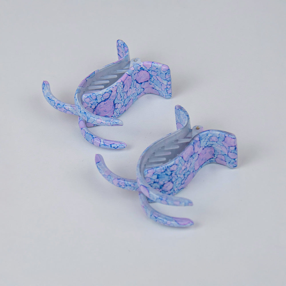 A pair of two long teeth claw clips with blue and pink pattern