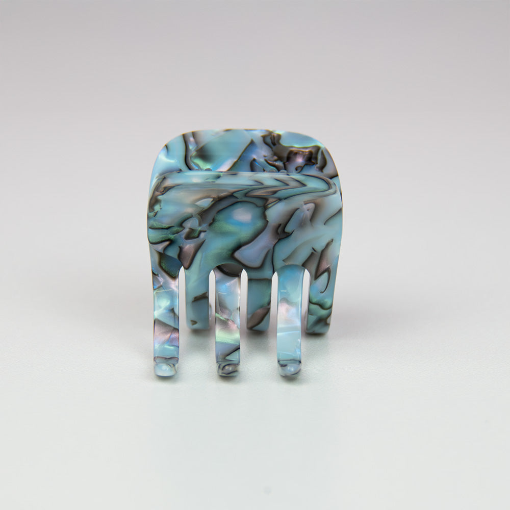 Marbled opal hair claw on a light gray background