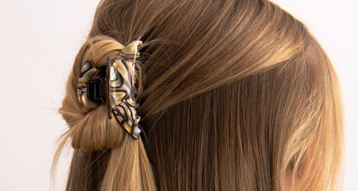 Fine brown hair held half up with a TEGEN claw clip