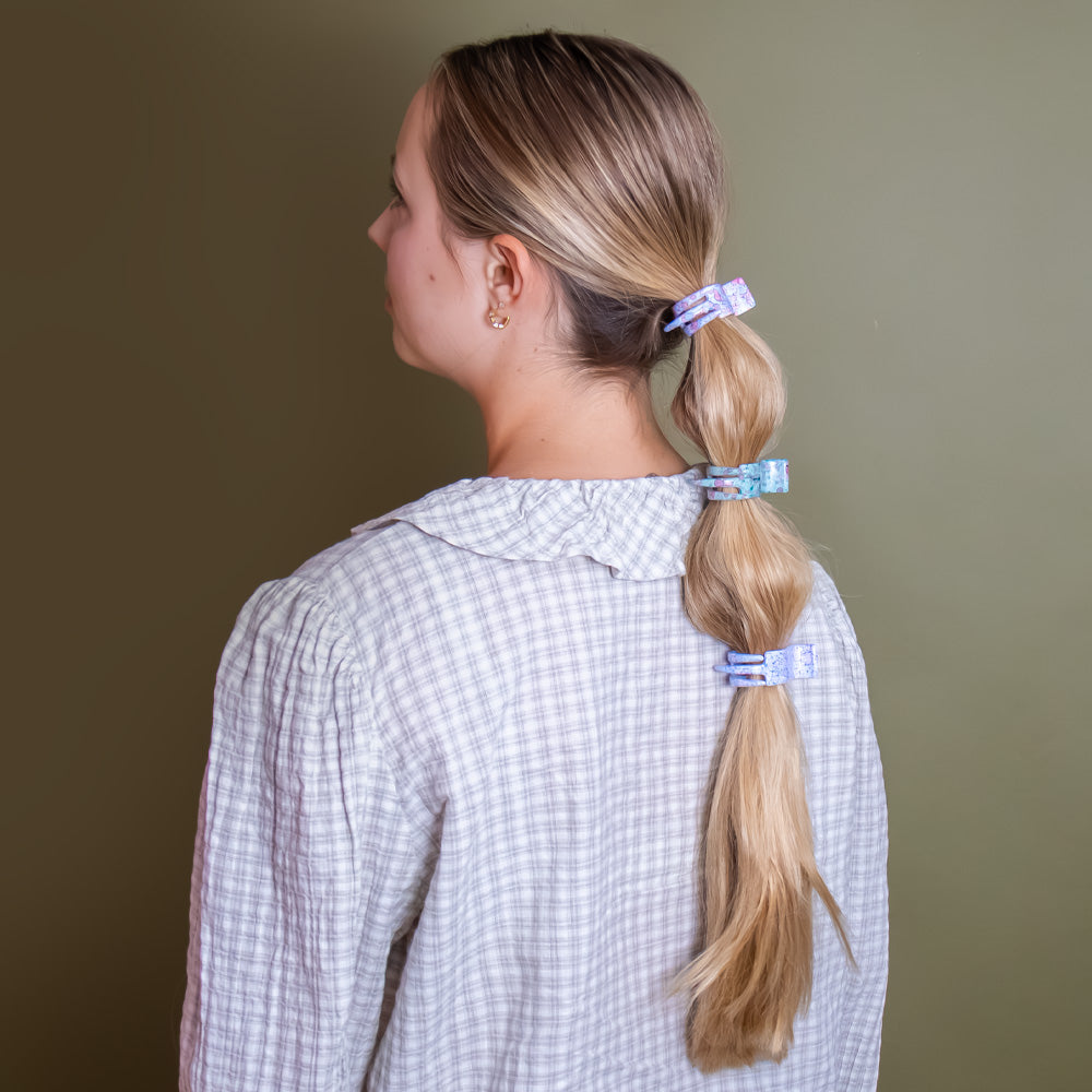 A pair of two long teeth claw clips with extra grip in blue green pink and coral floral design